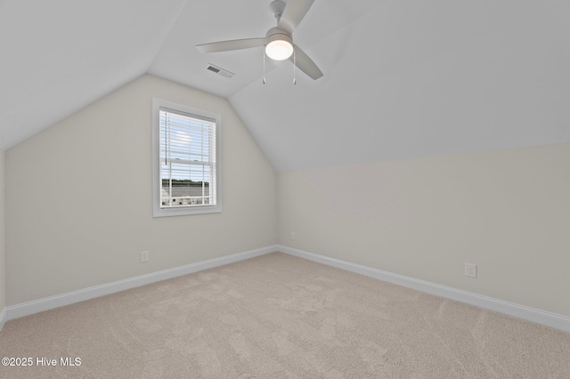 additional living space with carpet floors, lofted ceiling, visible vents, ceiling fan, and baseboards