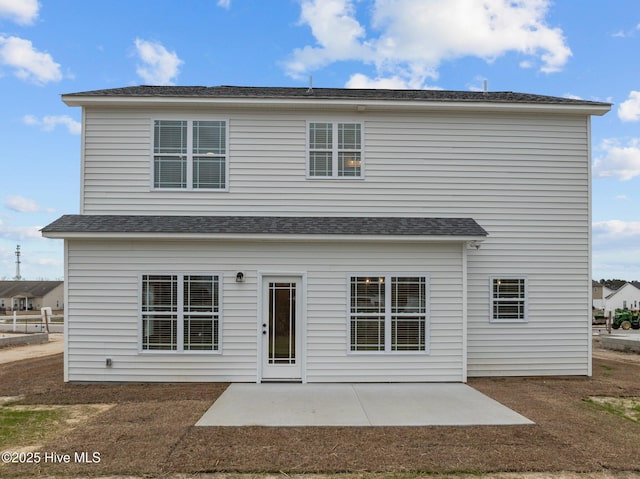 view of front of property with a patio area and a shingled roof