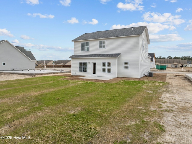 rear view of property with a yard, a patio, and central air condition unit