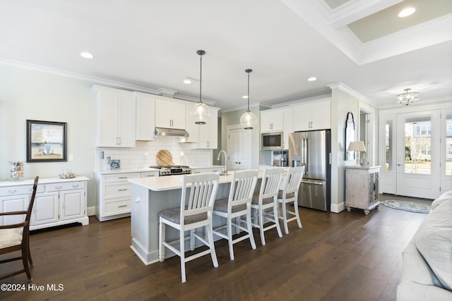 kitchen featuring built in microwave, stainless steel fridge with ice dispenser, decorative light fixtures, a center island with sink, and white cabinets