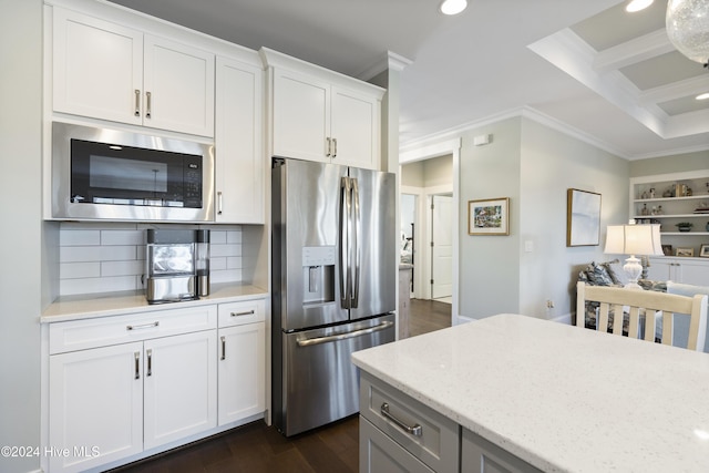 kitchen with white cabinets, stainless steel appliances, light stone counters, and tasteful backsplash