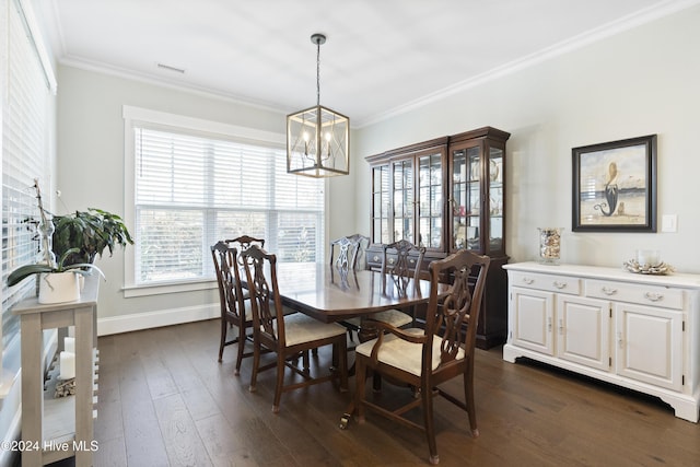 dining area featuring crown molding, dark hardwood / wood-style floors, and an inviting chandelier