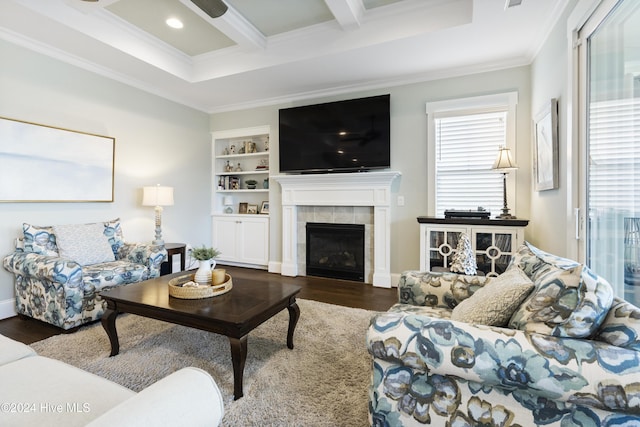 living room featuring a tile fireplace, built in shelves, dark hardwood / wood-style floors, and beam ceiling