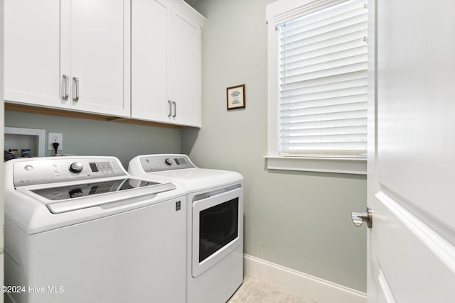 laundry area featuring cabinets, washing machine and dryer, and light tile patterned floors