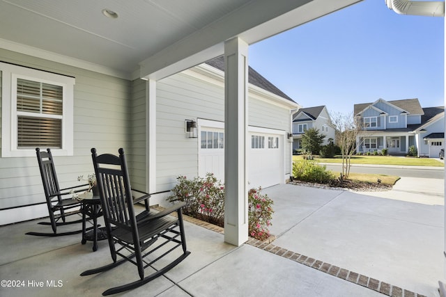 view of patio / terrace with covered porch and a garage