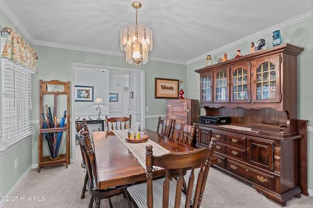 carpeted dining area with crown molding and an inviting chandelier