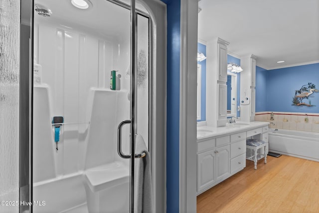 bathroom with shower with separate bathtub, hardwood / wood-style floors, and vanity