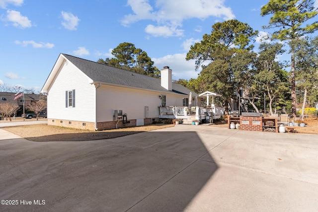 back of property featuring a wooden deck and a patio