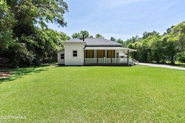 401 Pecan Ln, Lake Waccamaw, NC 28450 - rear view of house featuring a porch and a lawn