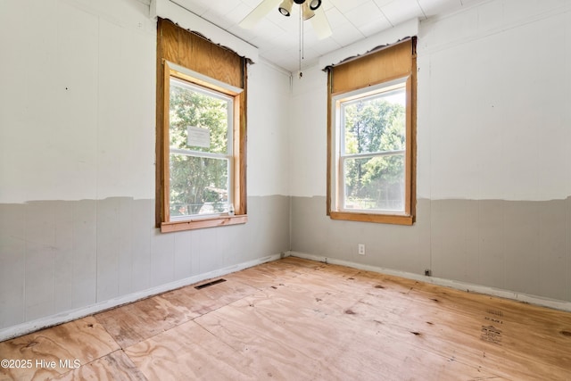 401 Pecan Ln, Lake Waccamaw, NC 28450 - unfurnished room featuring a ceiling fan, wooden walls, and a wainscoted wall