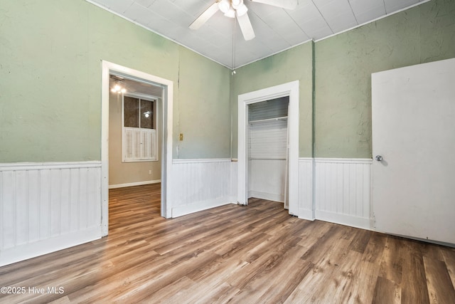 401 Pecan Ln, Lake Waccamaw, NC 28450 - unfurnished bedroom featuring wood finished floors, a closet, a wainscoted wall, and ceiling fan