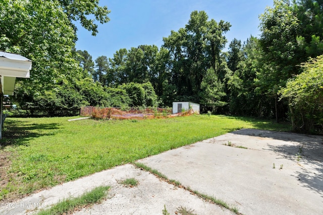 401 Pecan Ln, Lake Waccamaw, NC 28450 - view of green lawn with a storage unit and a patio area
