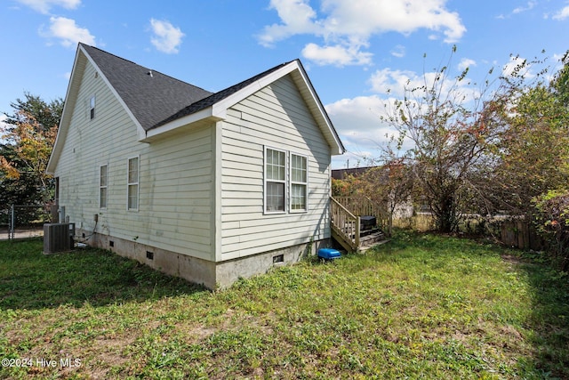 view of property exterior with a yard and central air condition unit