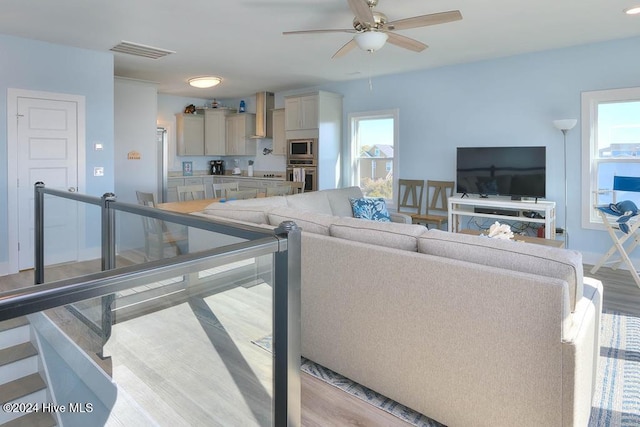 living room with light hardwood / wood-style floors and ceiling fan