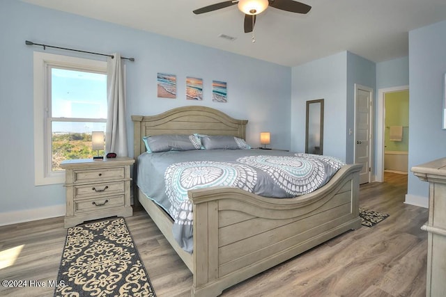 bedroom featuring hardwood / wood-style flooring, ceiling fan, and ensuite bathroom