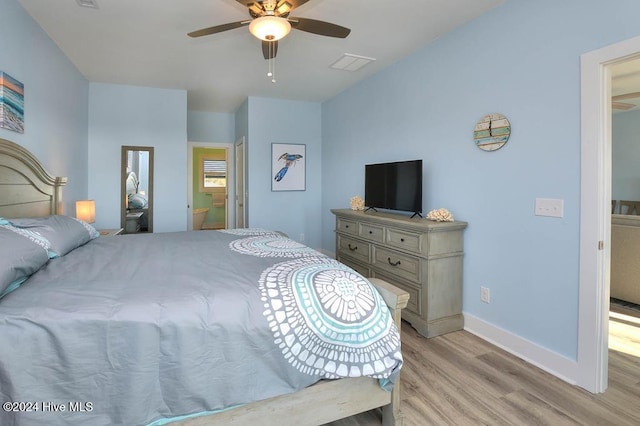 bedroom featuring light hardwood / wood-style flooring, ensuite bath, and ceiling fan