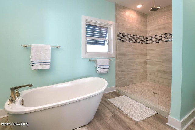 bathroom with hardwood / wood-style floors and shower with separate bathtub