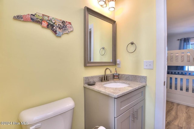 bathroom featuring hardwood / wood-style flooring, vanity, and toilet