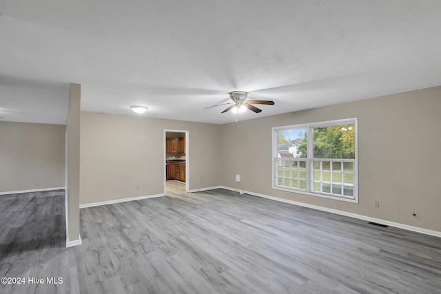 spare room with ceiling fan and light wood-type flooring