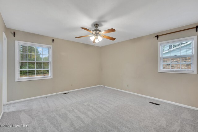 carpeted spare room with ceiling fan