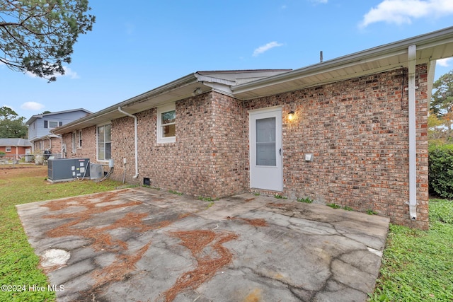 rear view of property with central AC unit and a patio area