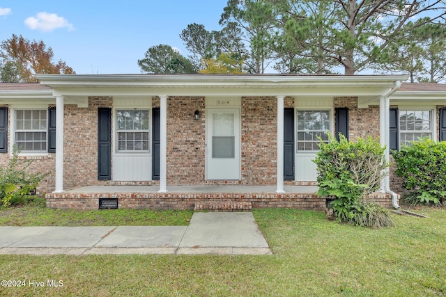 view of front facade featuring covered porch and a front yard