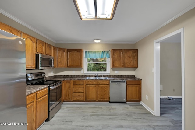 kitchen with light hardwood / wood-style floors, crown molding, sink, and appliances with stainless steel finishes