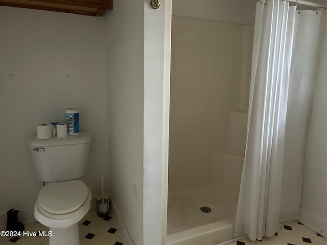 bathroom with toilet and a shower with shower curtain