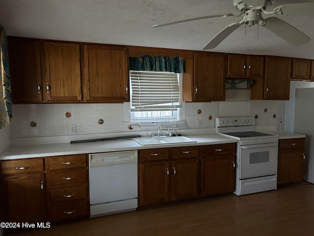 kitchen featuring white appliances, backsplash, dark wood-type flooring, sink, and range hood