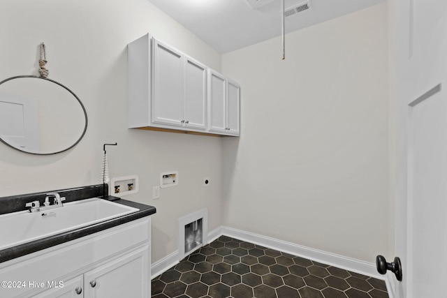 clothes washing area featuring cabinets, hookup for a washing machine, dark tile patterned floors, and electric dryer hookup