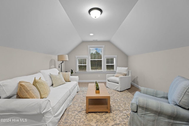 carpeted living room featuring lofted ceiling