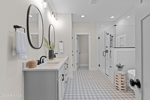 bathroom with tile patterned flooring, vanity, and a shower with shower door