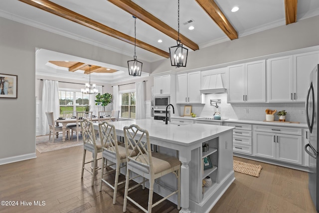 kitchen with dark hardwood / wood-style floors, white cabinetry, an island with sink, and custom exhaust hood