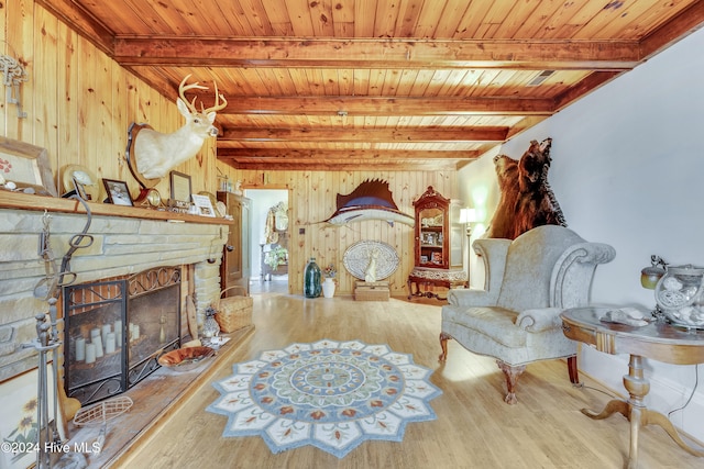 sitting room with beamed ceiling, wooden walls, wood ceiling, and hardwood / wood-style flooring