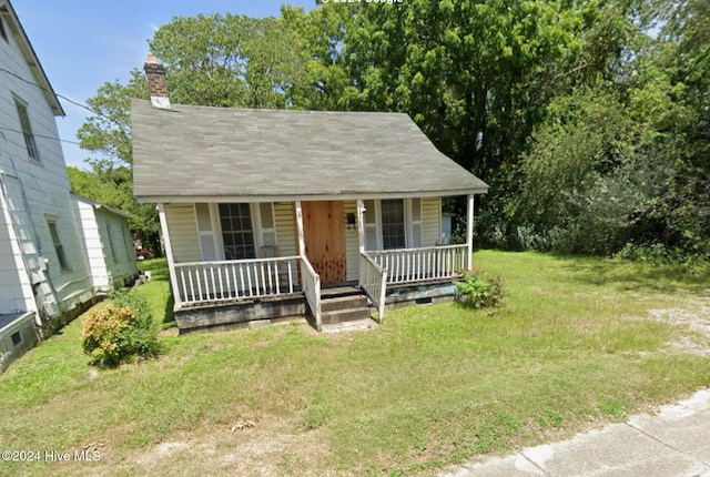 bungalow-style home with covered porch and a front yard