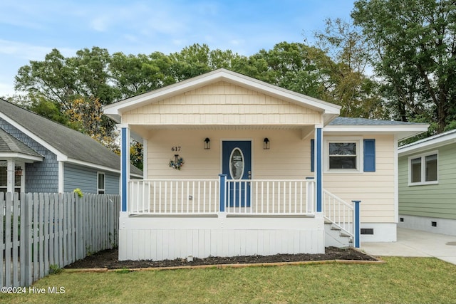 bungalow-style house featuring covered porch and a front yard