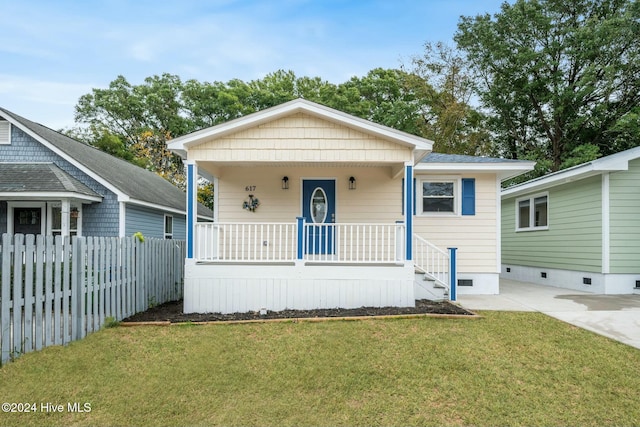 bungalow-style house featuring covered porch and a front yard