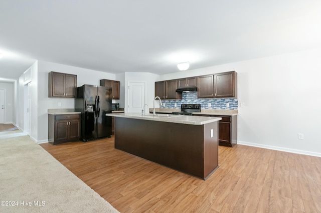 kitchen featuring black appliances, light hardwood / wood-style floors, dark brown cabinetry, and sink