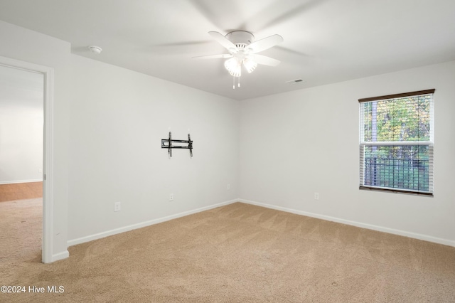 spare room featuring ceiling fan and light carpet