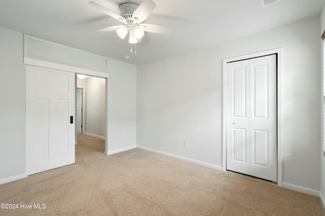 unfurnished bedroom with ceiling fan, a closet, and light carpet