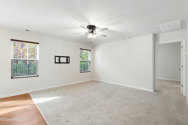 unfurnished room with light colored carpet and ceiling fan