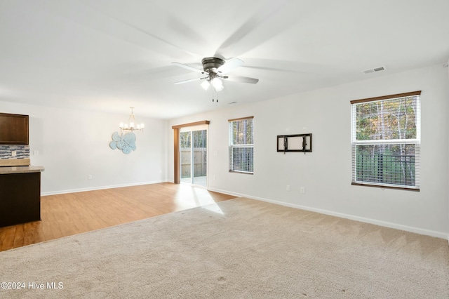 spare room featuring light hardwood / wood-style flooring and ceiling fan with notable chandelier