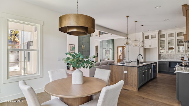 dining space featuring a wealth of natural light, sink, and dark hardwood / wood-style floors