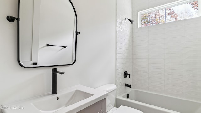 full bathroom featuring vanity, tiled shower / bath combo, and toilet