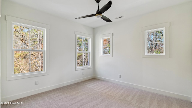 unfurnished room featuring light carpet and ceiling fan