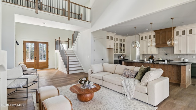 living room with french doors, a high ceiling, and hardwood / wood-style flooring