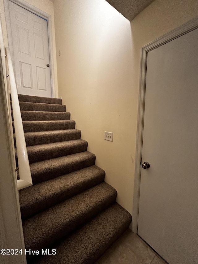 stairway with tile patterned floors