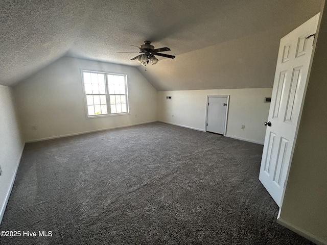 additional living space with ceiling fan, vaulted ceiling, and dark colored carpet