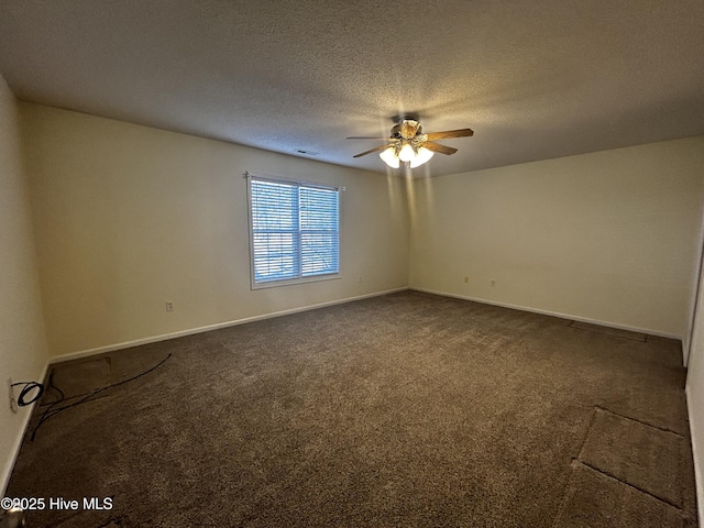 spare room featuring ceiling fan, dark carpet, and a textured ceiling