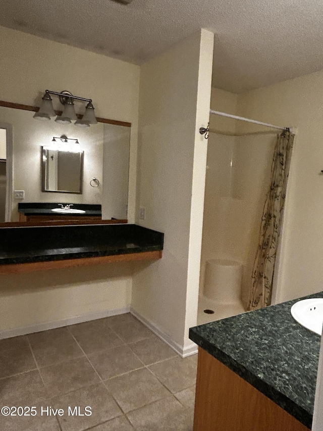 bathroom featuring vanity, a textured ceiling, curtained shower, and tile patterned flooring